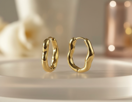 A pair of chunky gold twisted hoop earrings with a shiny finish.