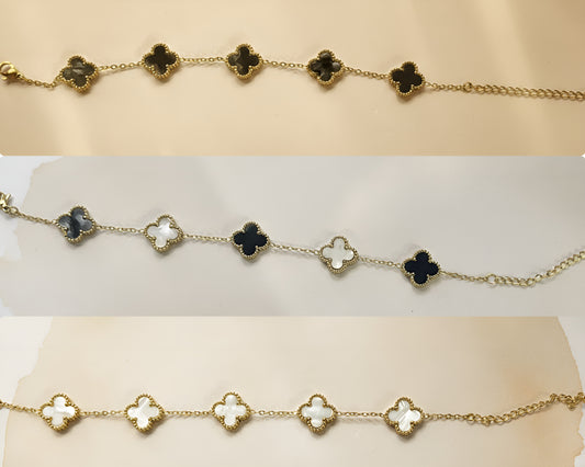 Gold bracelet with clover-shaped charms on a white background