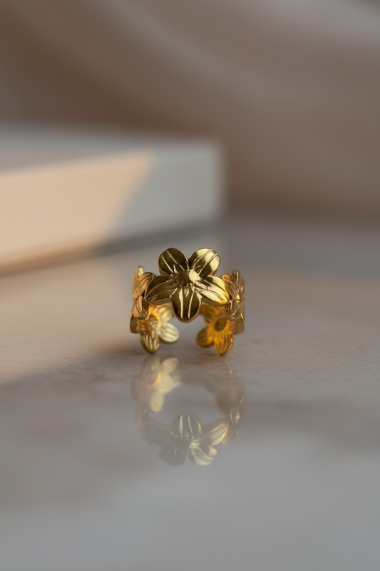 Gold adjustable ring with detailed floral design and polished textured finish.