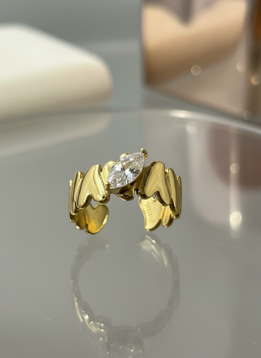Gold plated ring with marquise-cut diamond and wavy heart design.