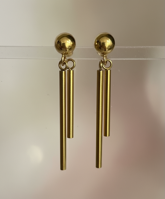 Gold drop earrings with double bar design and polished finish on clear stand